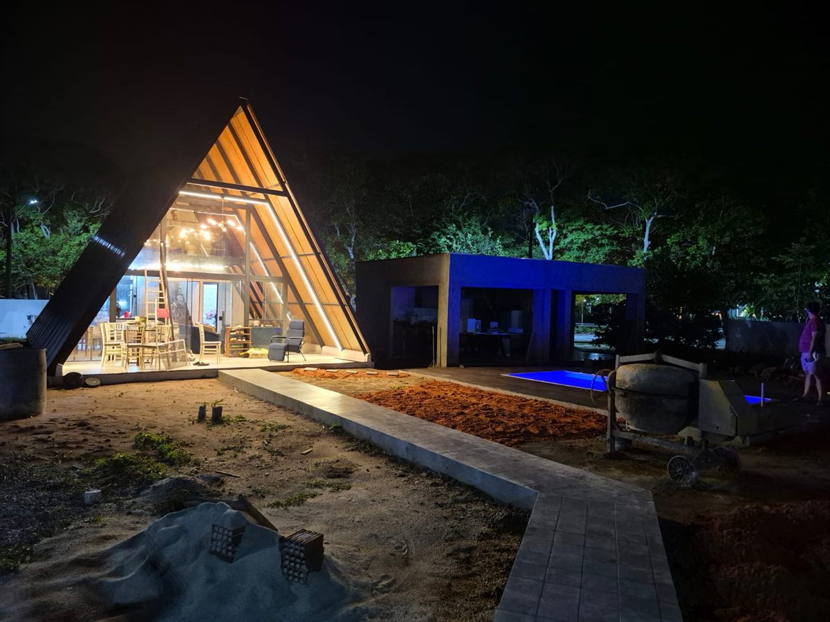Chalé A-frame iluminado à noite com cobertura termoacústica, obra de alto padrão na Lagoa do Bomfim