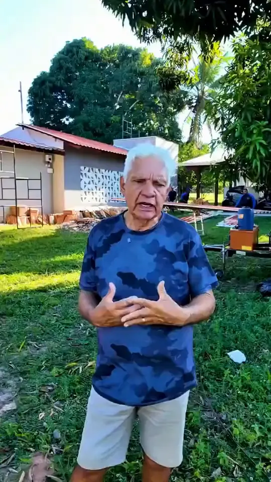 Cliente de camisa azul em frente à casa com telhado terracota dá depoimento sobre a troca das telhas